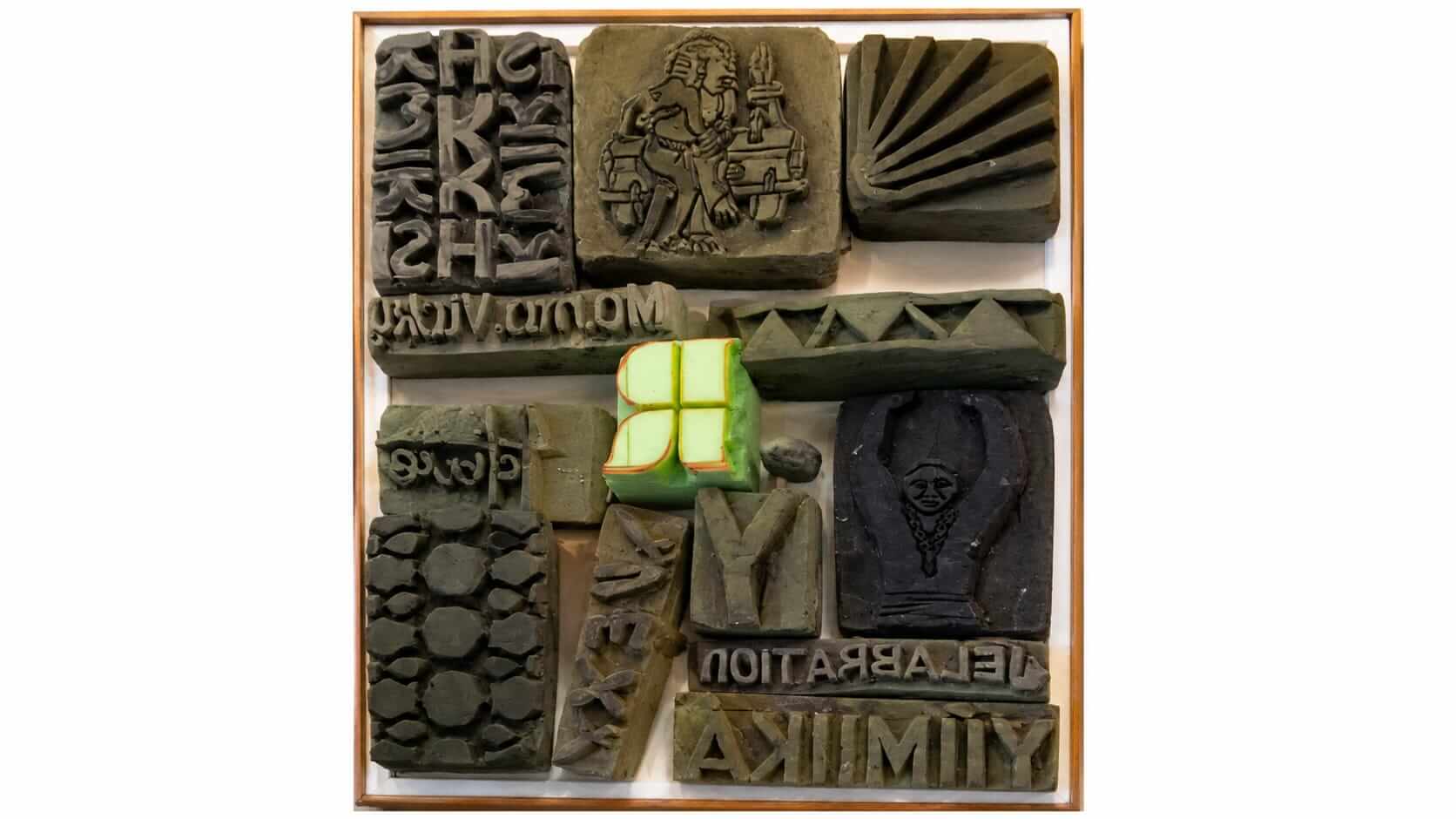 Colorful abstract textile art featuring layered and textured fabric swatches in warm tones.