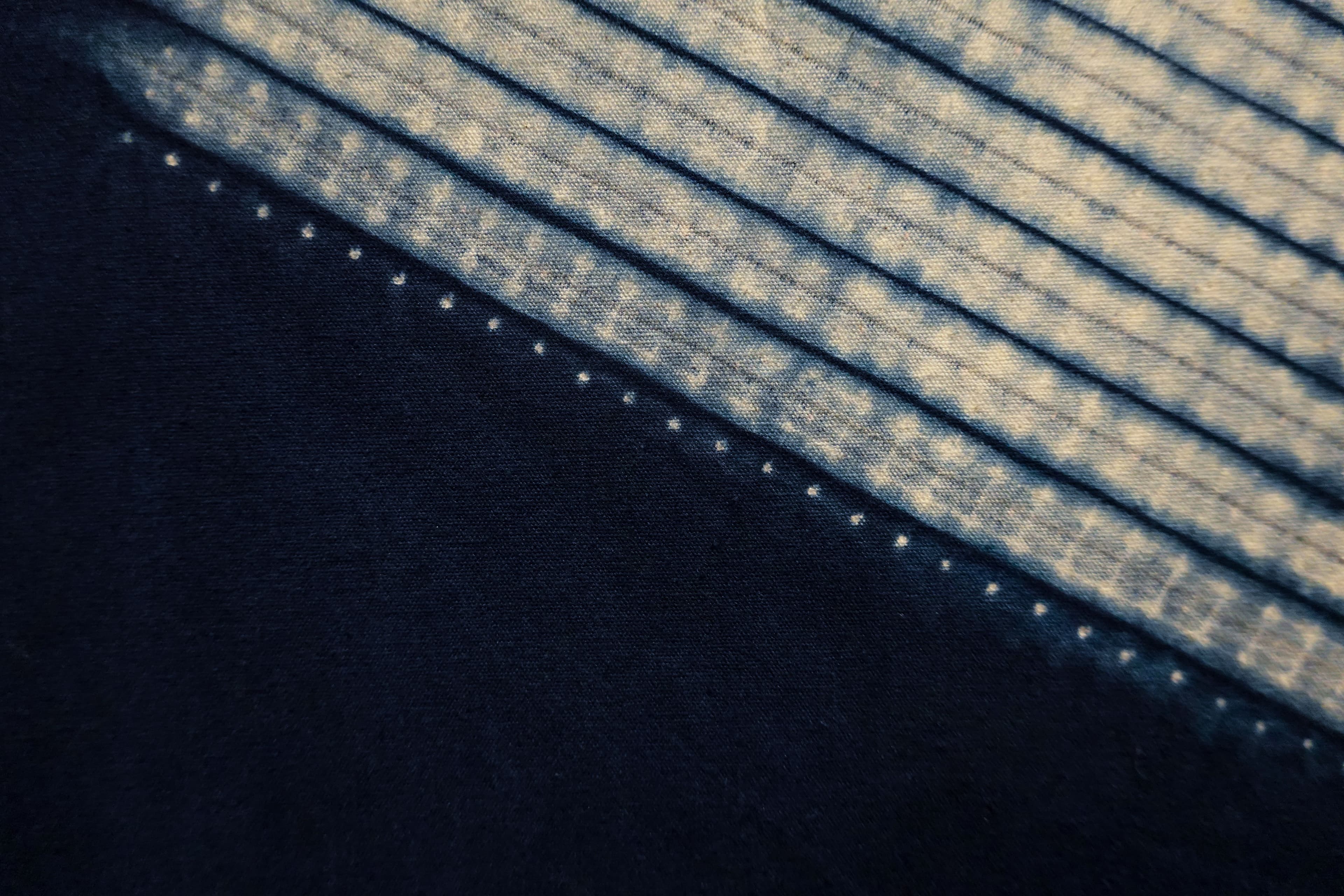 Close-up of indigo-dyed fabric showcasing unique geometric patterns and textures.